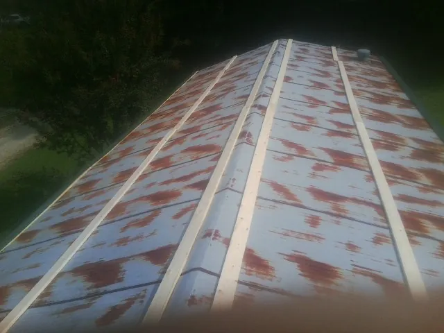 Rusted metal roof panels with new wood purlins before replacement — Storm Damage Roof Repair in Edgerton by Roofing Brothers